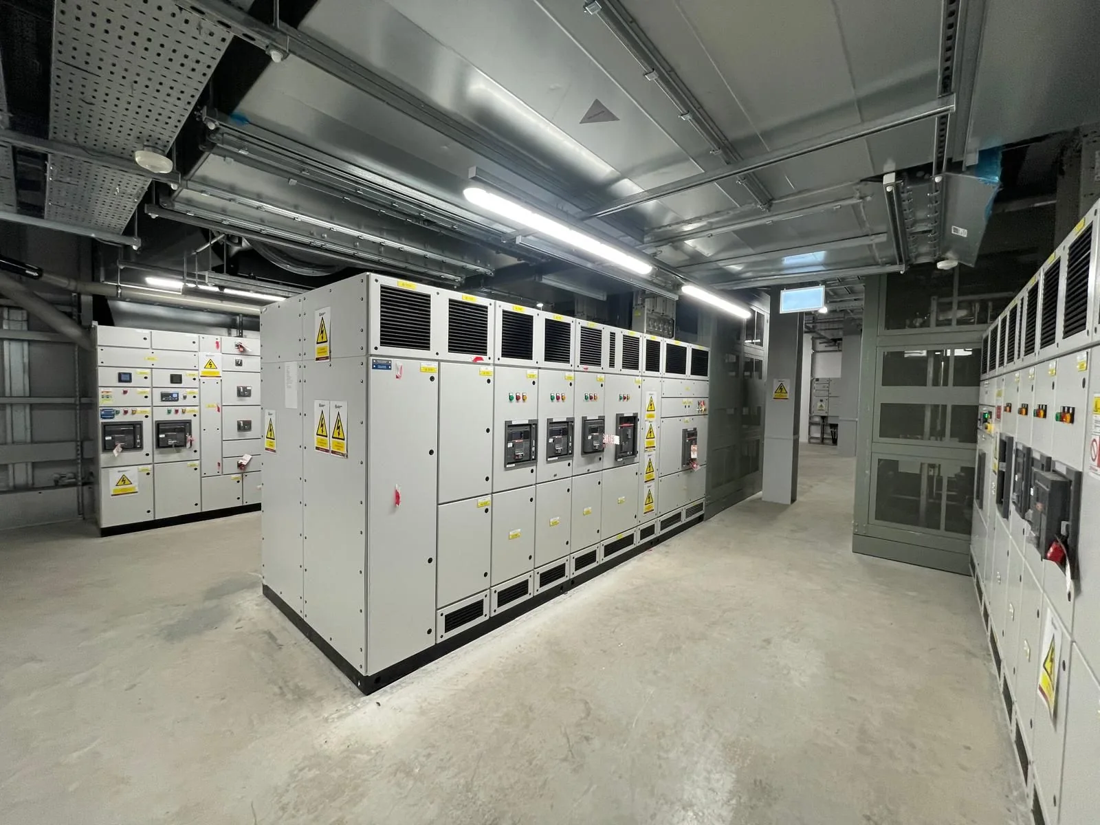 Electrical switchgear room with distribution panels, overhead cable containment and lighting